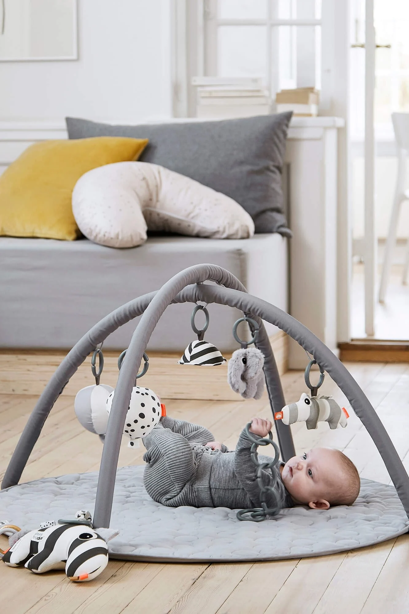 A smiling octopus soft toy lays on a quilted floor mat. Soft toys are the perfect baby shower gift idea for the little one. 
