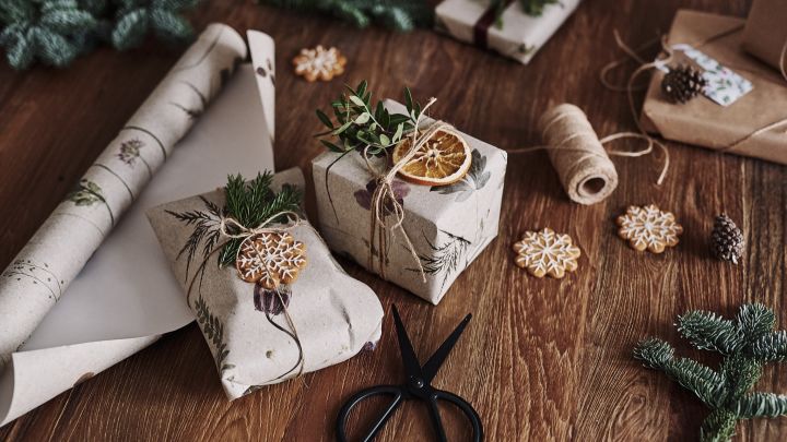 The Christmas gifts are waiting on the table, wrapped in floral wallpaper - a more sustainable Christmas gift packaging.