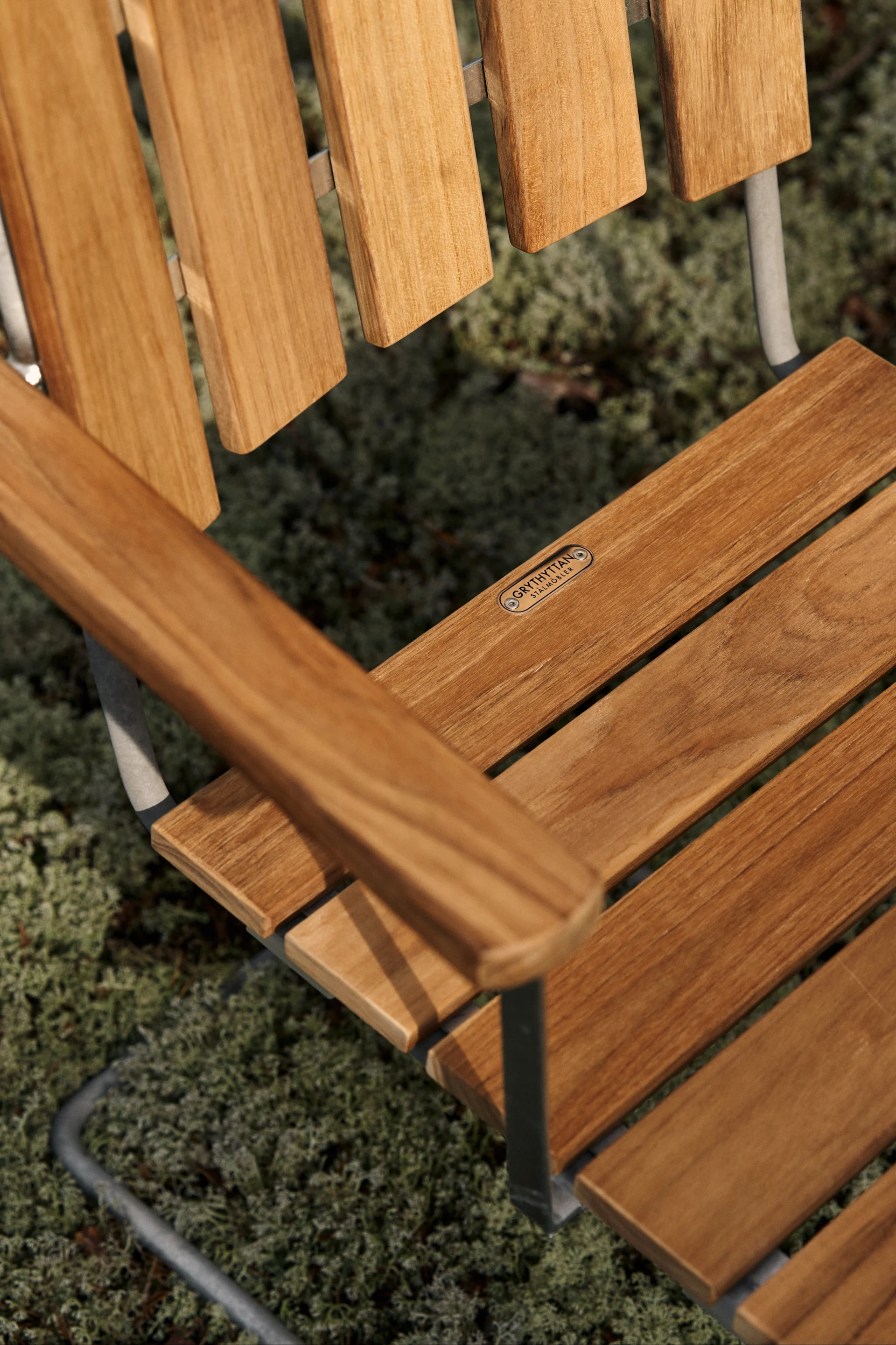 A close up of the A2 chair from Grythyttan Stålmöbler a real classic among outdoor furniture in teak, this chair is best taken care of by cleaning it properly each new season and you can also choose to oil it if you want to keep the teak's natural red-brown colour.