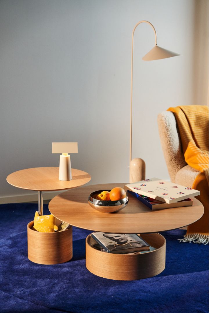 The small and large Parasol table from Maze on a blue rug with the Little Petra armchair. 