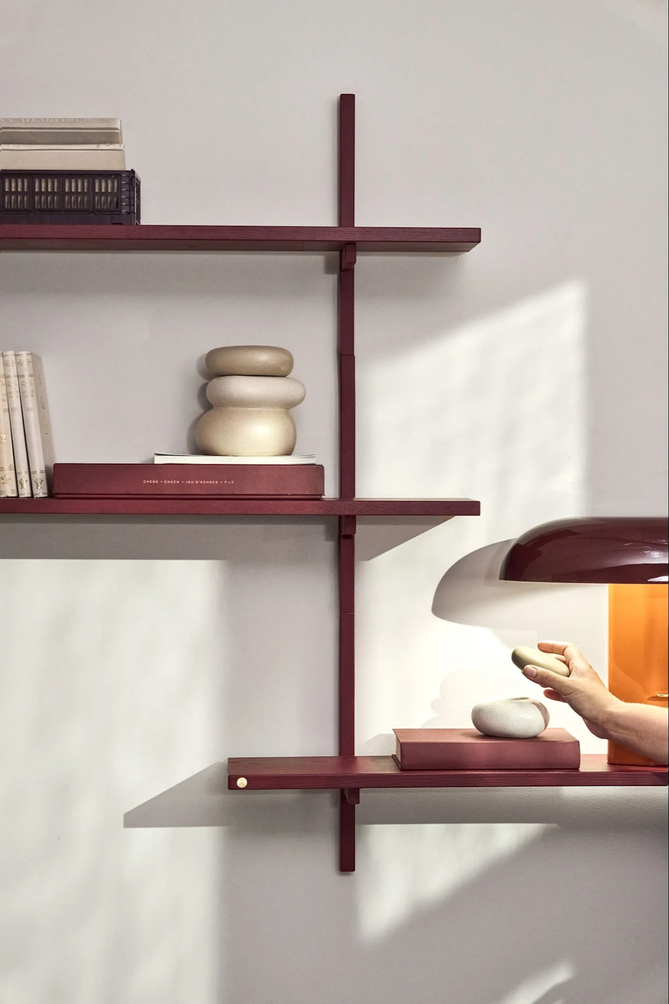 Plum shades in the colour trends for 2026, shown here through a shelf and lamp in a plum red tone.