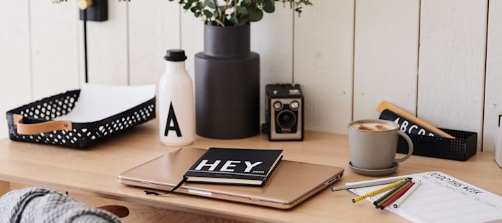 A small home office with design letter diary, weekly planner and water bottle.