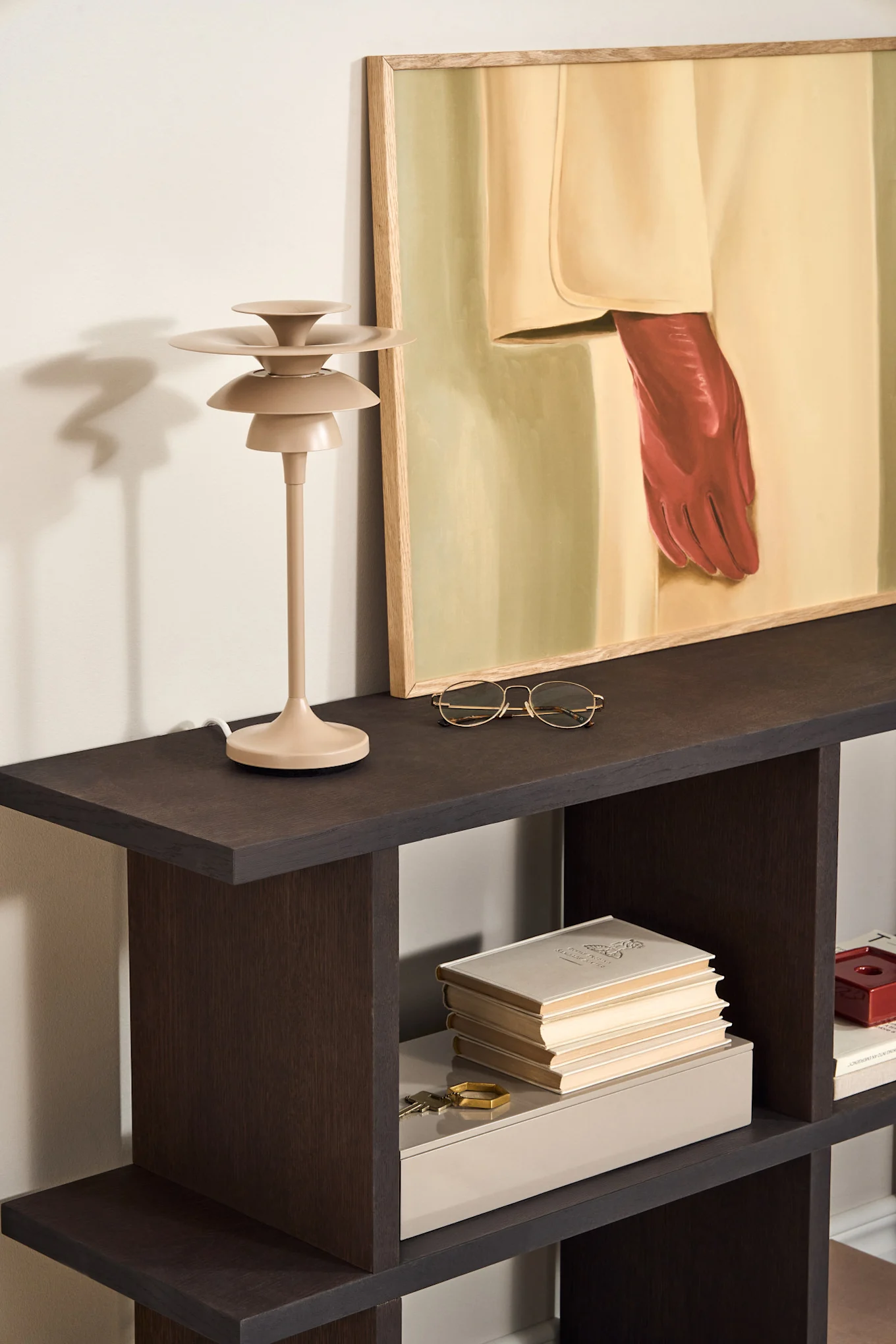 Layer your dining room lighting ideas. Here you see the Picasso table lamp in beige from Belid standing on a side table. 