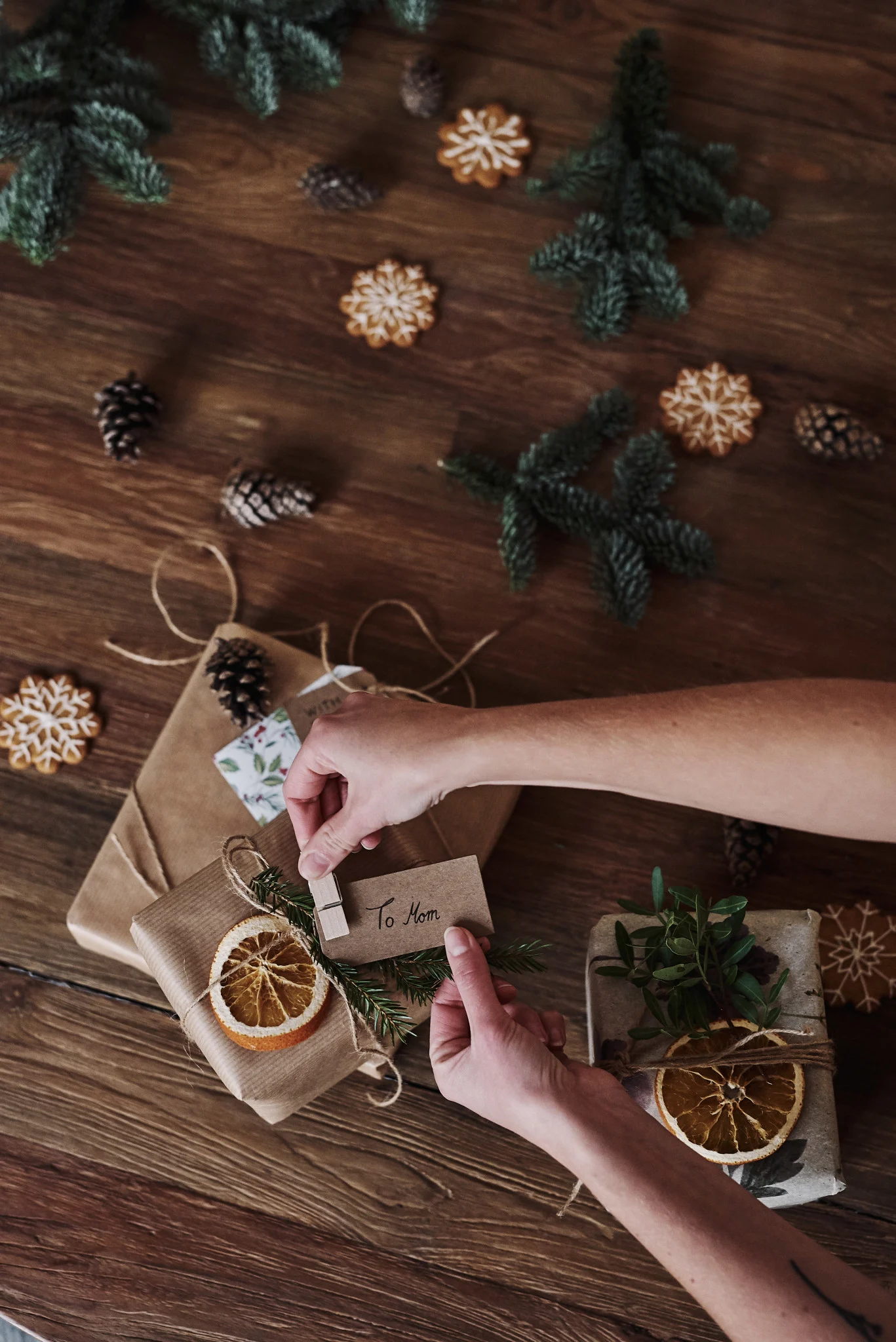 Gifts are also part of Christmas in Sweden, of course. Here, wrapped gifts lie on the table and a few hands pin name tags to them.