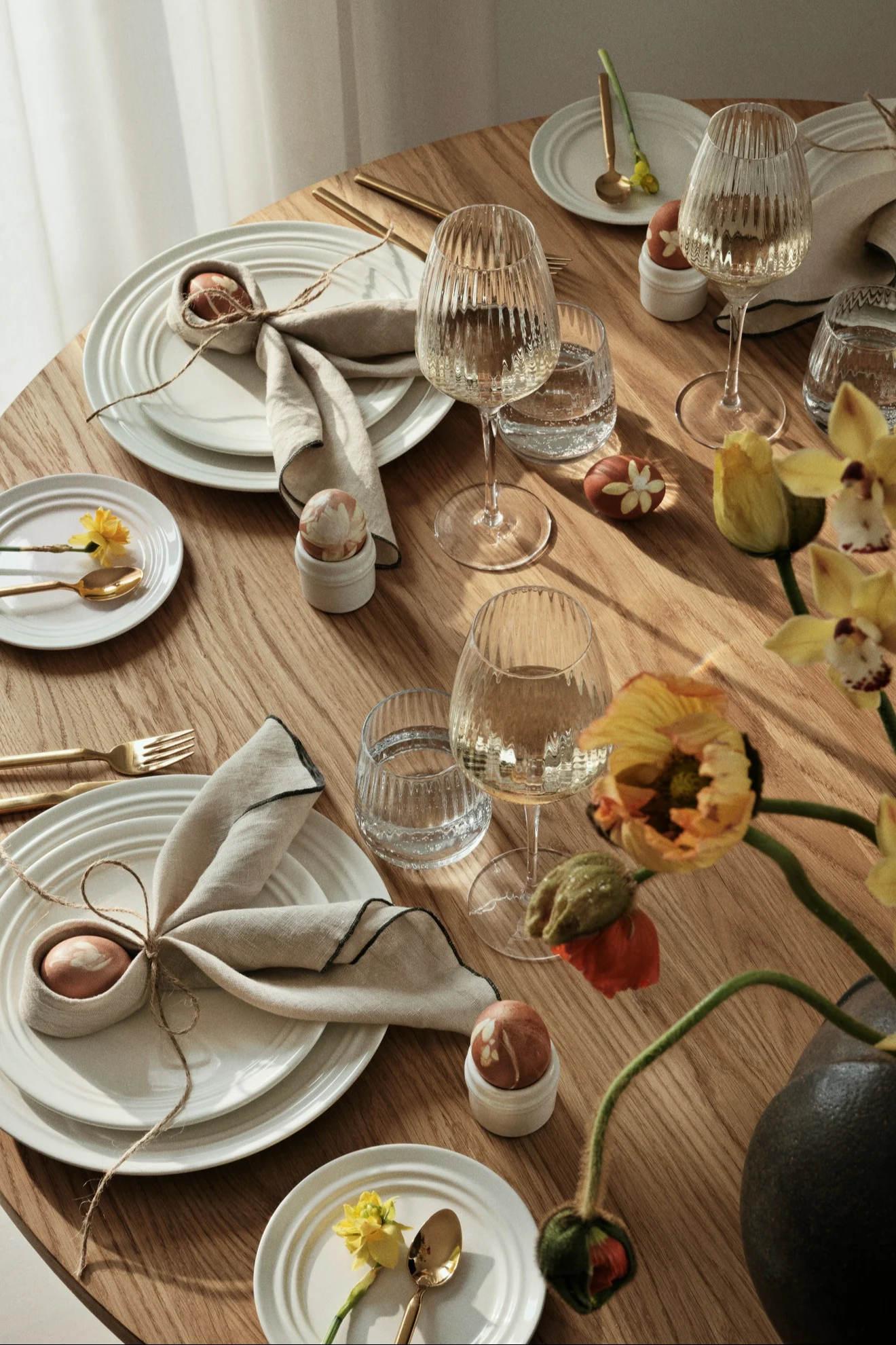 The dining table is set with crockery, glasses and cutlery from Broste Copenhagen, the napkins are folded in the shape of bunny ears.