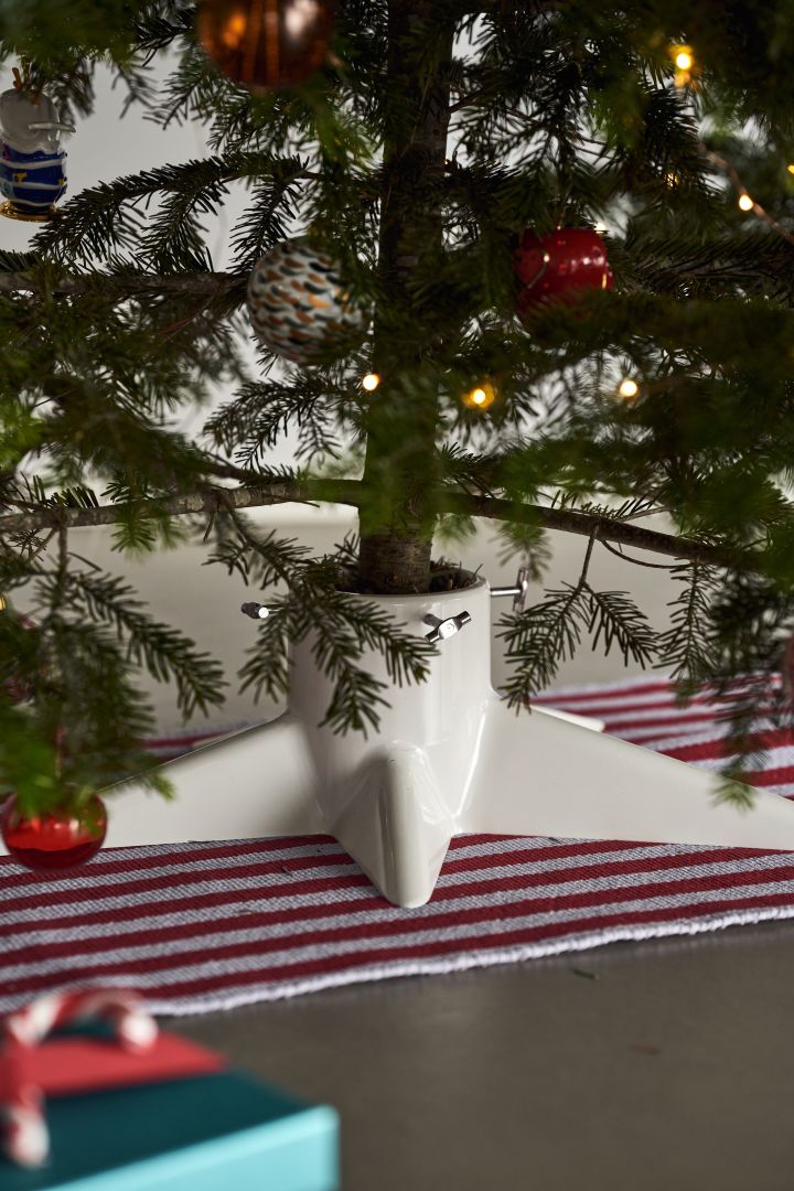 Decorate the Christmas tree with Christmas tree decorations for 2021 in 4 different styles according to Nest Trends - Nurture, Share, Boost and Cultivate. Here you see a striped rug from HAY in red and white and a white Christmas tree base from Born in Sweden.