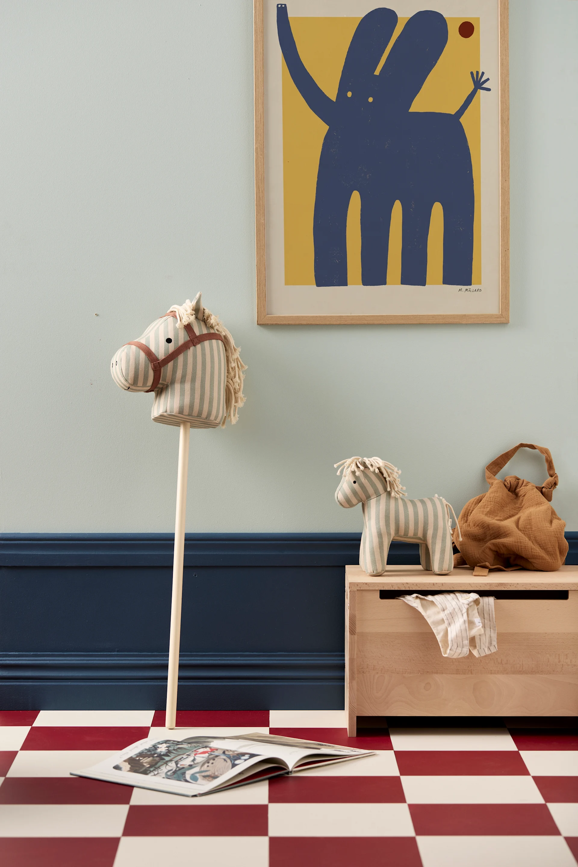Wooden furniture is a great idea for the children's bedroom, here you see the Saga wooden storage box from Kids Concept with a wooden hobby horse. 