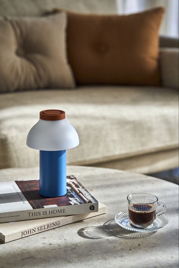 The PC portable table lamp in blue adds colour to the coffee table. 