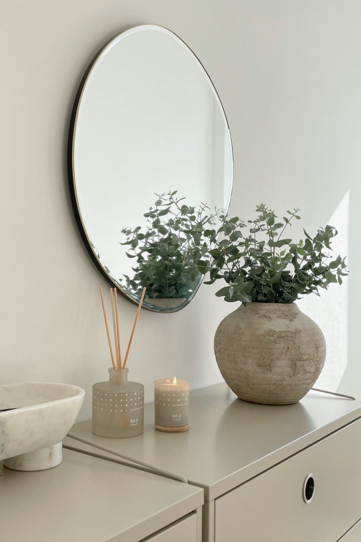 How to decorate a small hallway - inspiration from @our_home_living with scented candles from Skandinavisk and fresh flowers in a nice vase to make the hallway more inviting.