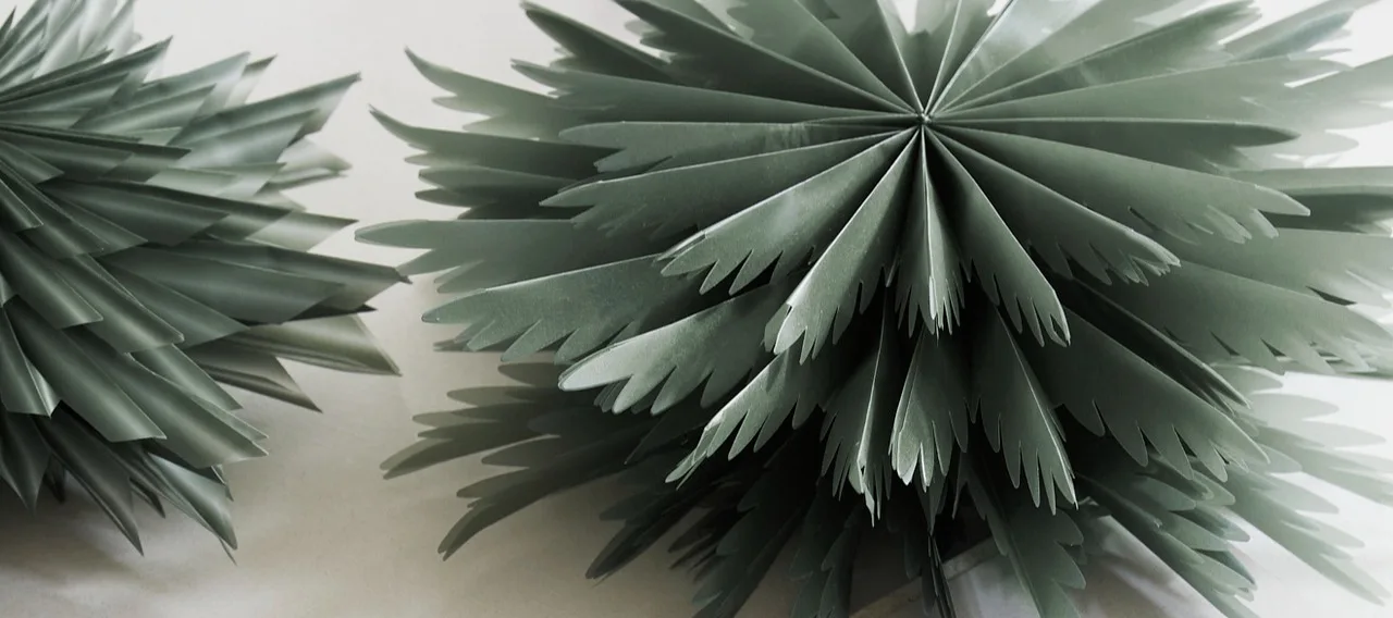 Two red paper star lanterns from Watt & Veke hanging in a living room setting.