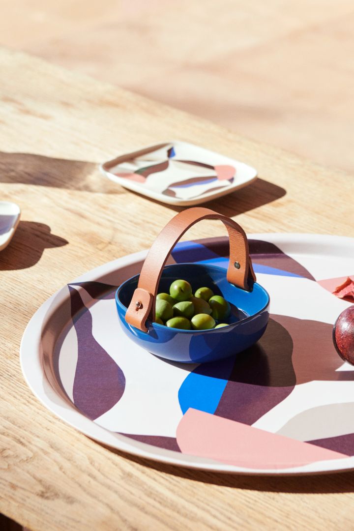 A blue bowl and multi coloured, patterned tray from Marimekko, two of the Scandinavian interior design trends for 2023. 
