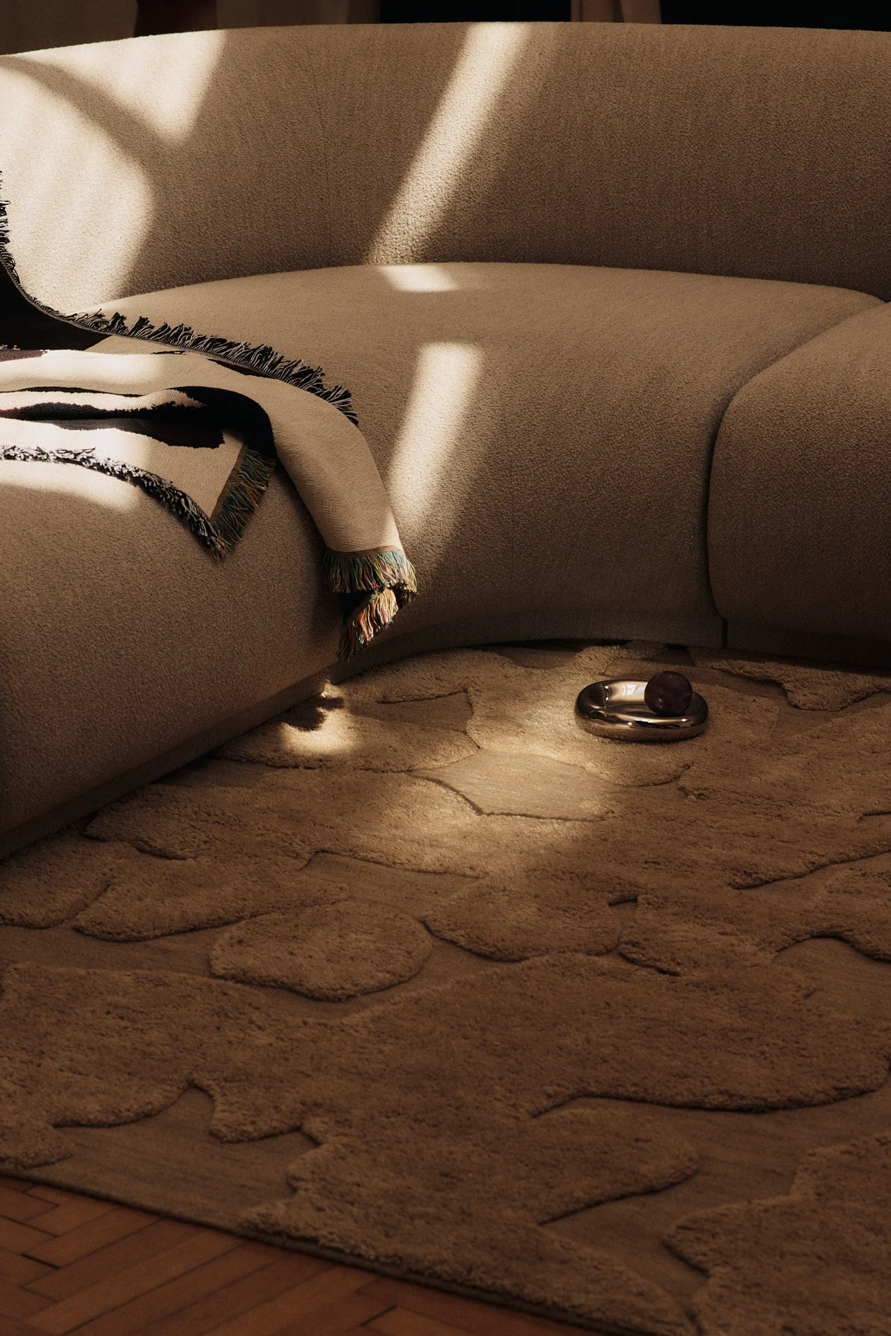 The colour trends of 2026 are reflected in this living room, where light brown furnishings are paired with a 1960s-inspired patterned rug in a kombucha shade.