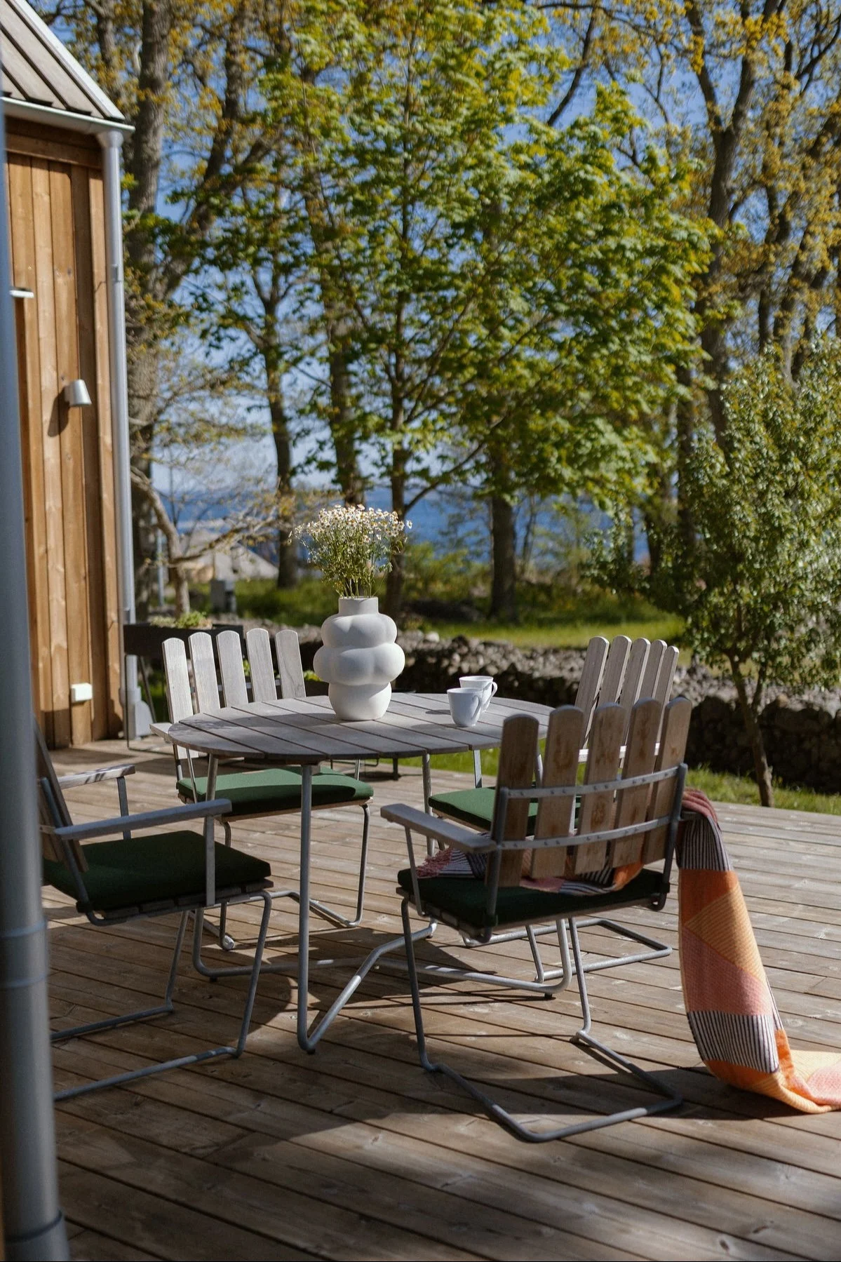 A small, cosy dining area on a wooden terrace with A2 chairs from Grythyttan.