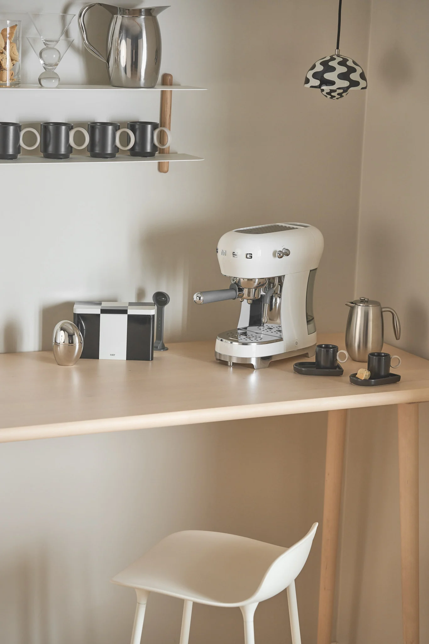 The coffee machine from Smeg, which you can see here standing in a corner, is particularly suitable for a coffee bar at home, with a Flowerpot pendant light from &tradition providing the lighting.
