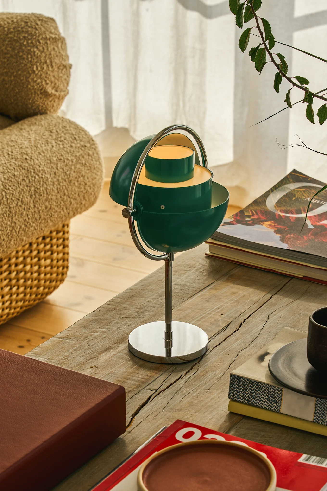 Emerald green and teal are part of the interior colour trends for 2026. Here, a teal lamp from GUBI is placed on a living room table.
