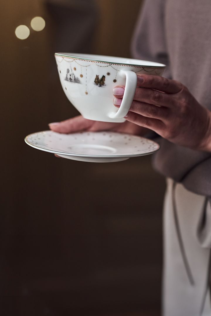 Here you see a hand placing the Julemorgon Christmas tableware onto a shelf. 