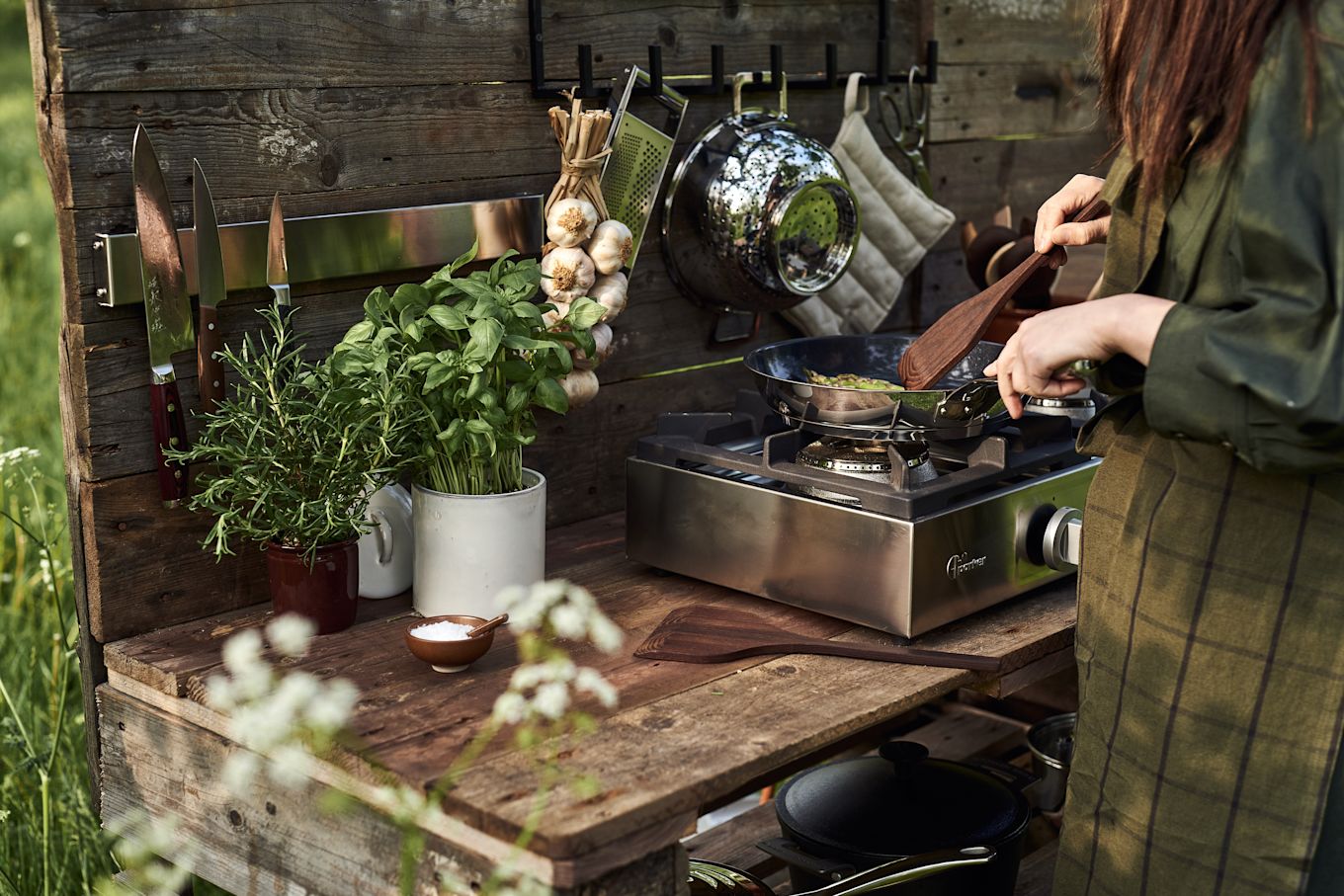 Woman cooking outdoors in an outdoor kitchen.