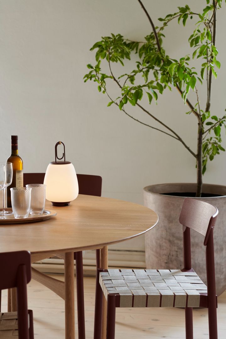 Japandi is the style that combines both Scandi and Japanese interior styles like you see here with the Betty lamp from &tradition standing on a dining table with a small indoor tree. 