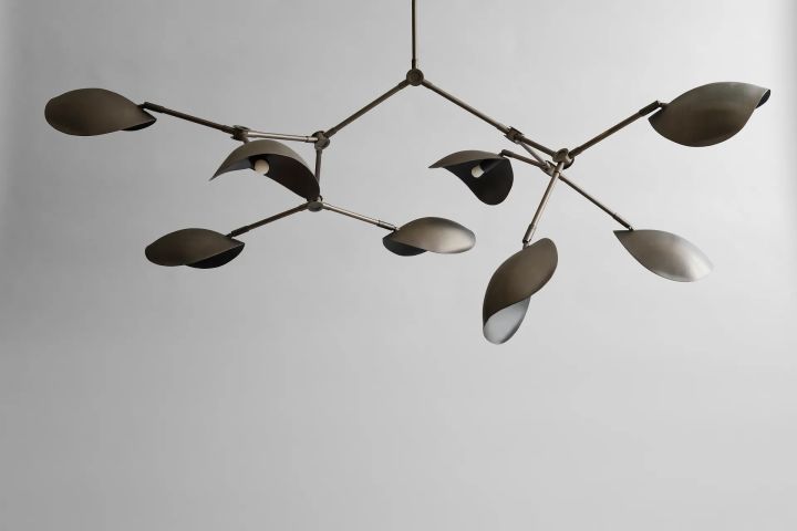 The Stingray Chandelier from 101 Copenhagen is a large ceiling lamp with a modern design. The lamp has several arms fitted with shades that have a shape inspired by stingrays.