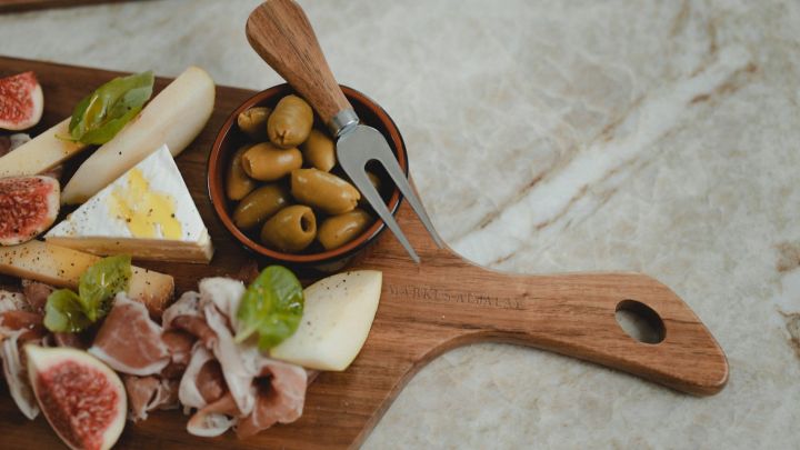 Cutting board from the brand and master chef Markus Aujalay with delicious tapas in the form of olives, cheese and figs.