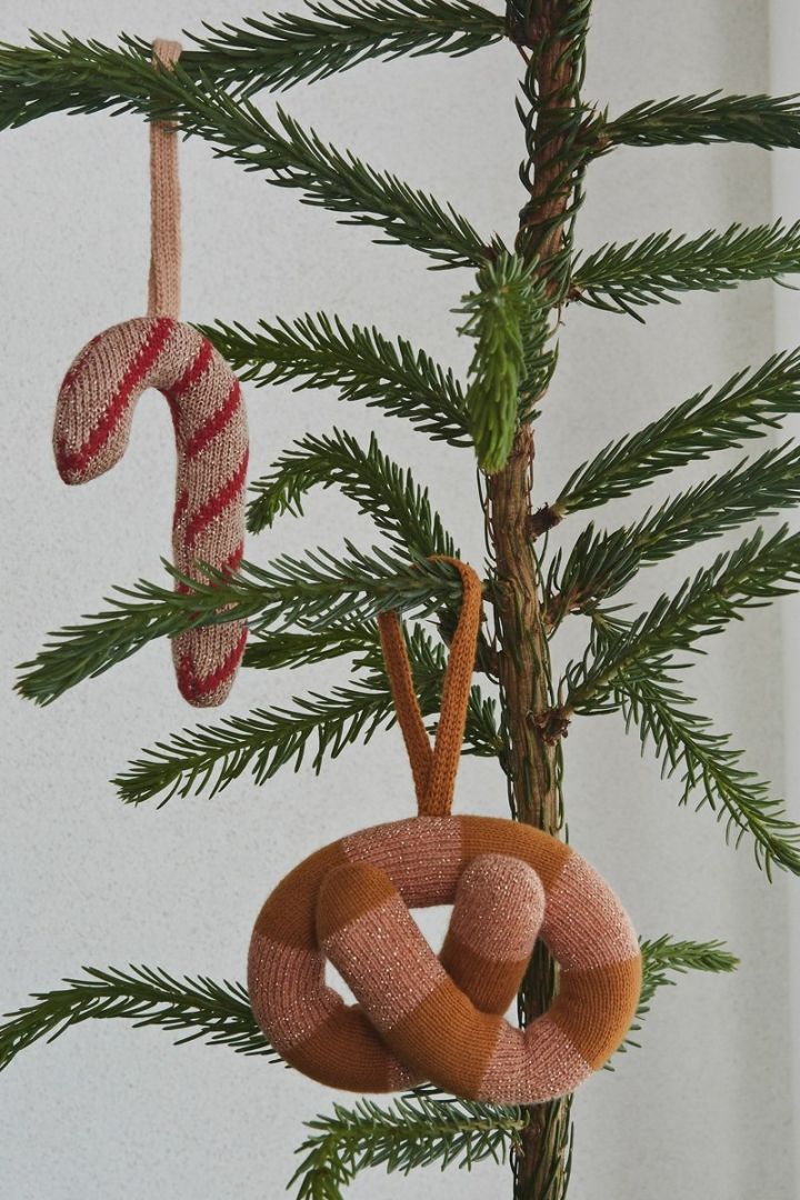 Stylish Christmas Decorations 2021 – knitted candy canes and pretzels by OYOY hung in a Christmas Tree.
