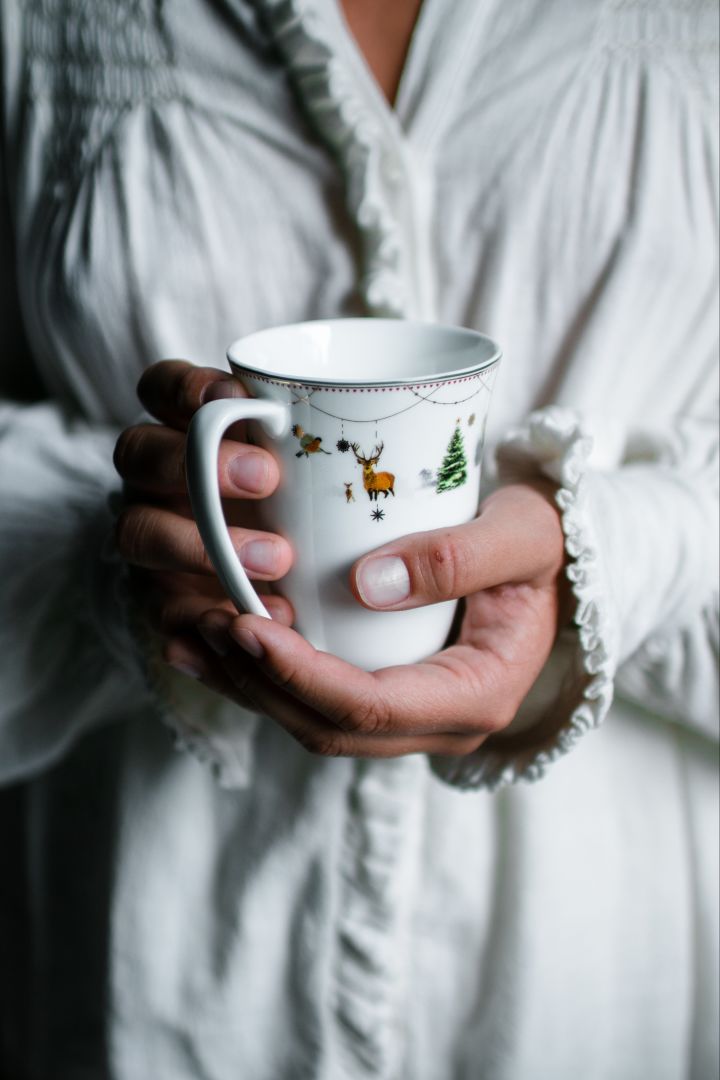 Someone warms their hands on the Julemorgon mug from Wik & Walsøe.