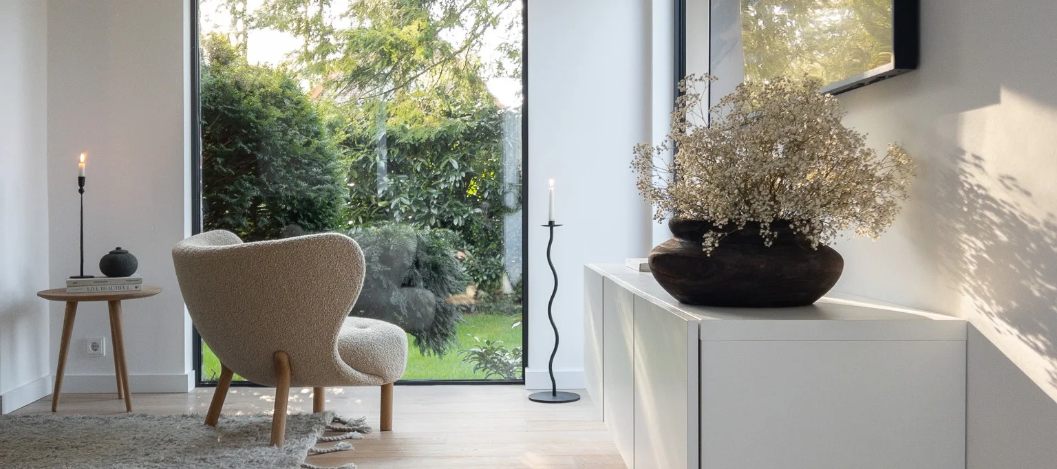 Here you see a Scandinavian style home with the little petra arm chair positioned in the window next to the curve floor candle holder from Cooee Design.