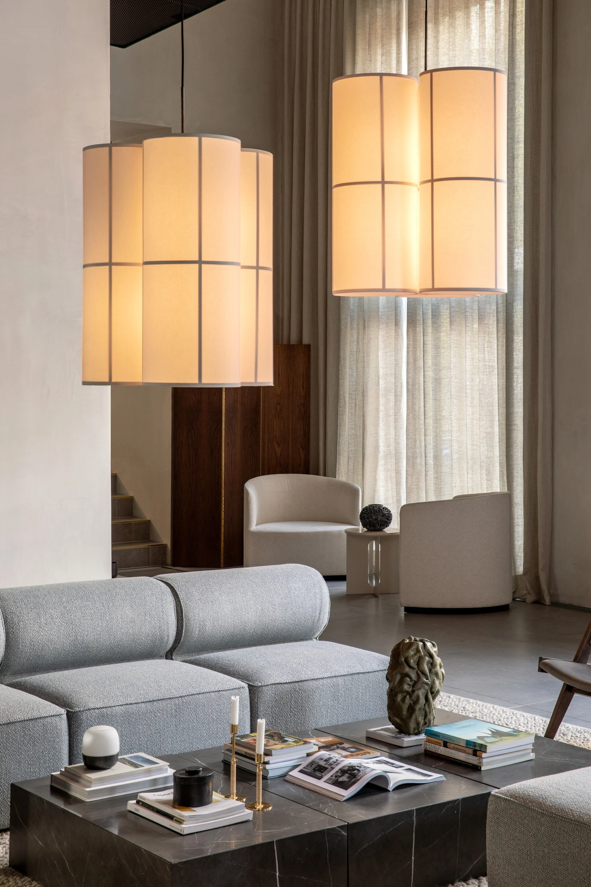 The Hashira Cluster pendant lamp by Audo Copenhagen hangs in a living room above the coffee table.