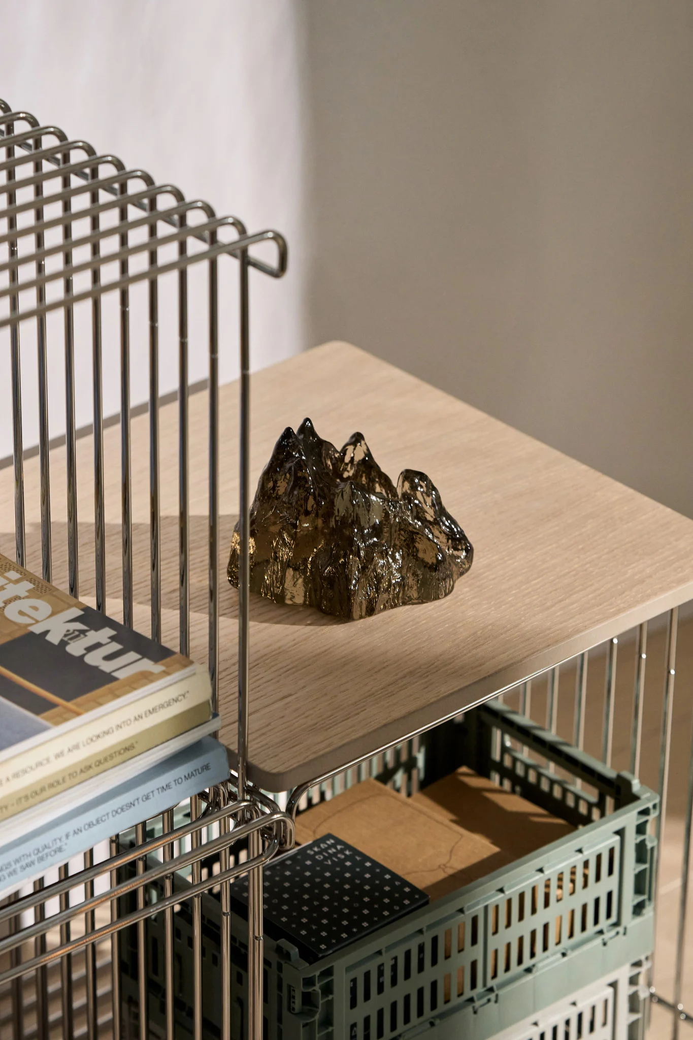The brown The Rock candle holder by Kosta Boda stands on a Panton Wire shelf.