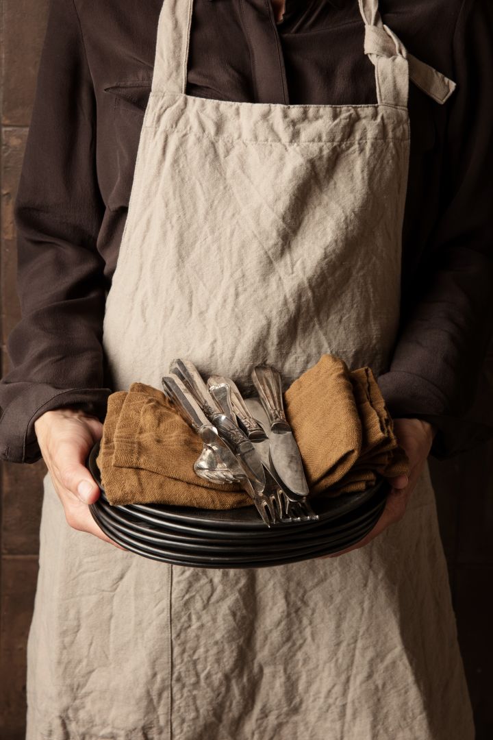 Renew your kitchen with 11 practical and stylish kitchen accessories for easier cooking - here you see the stylish Hale apron in the colour Sand from Ferm Living.