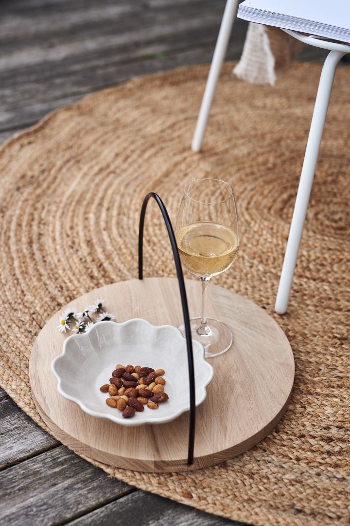 A Mateus bowl filled with nuts sits on the oak tray from Woud. Two summer essentials for a day in the garden. 