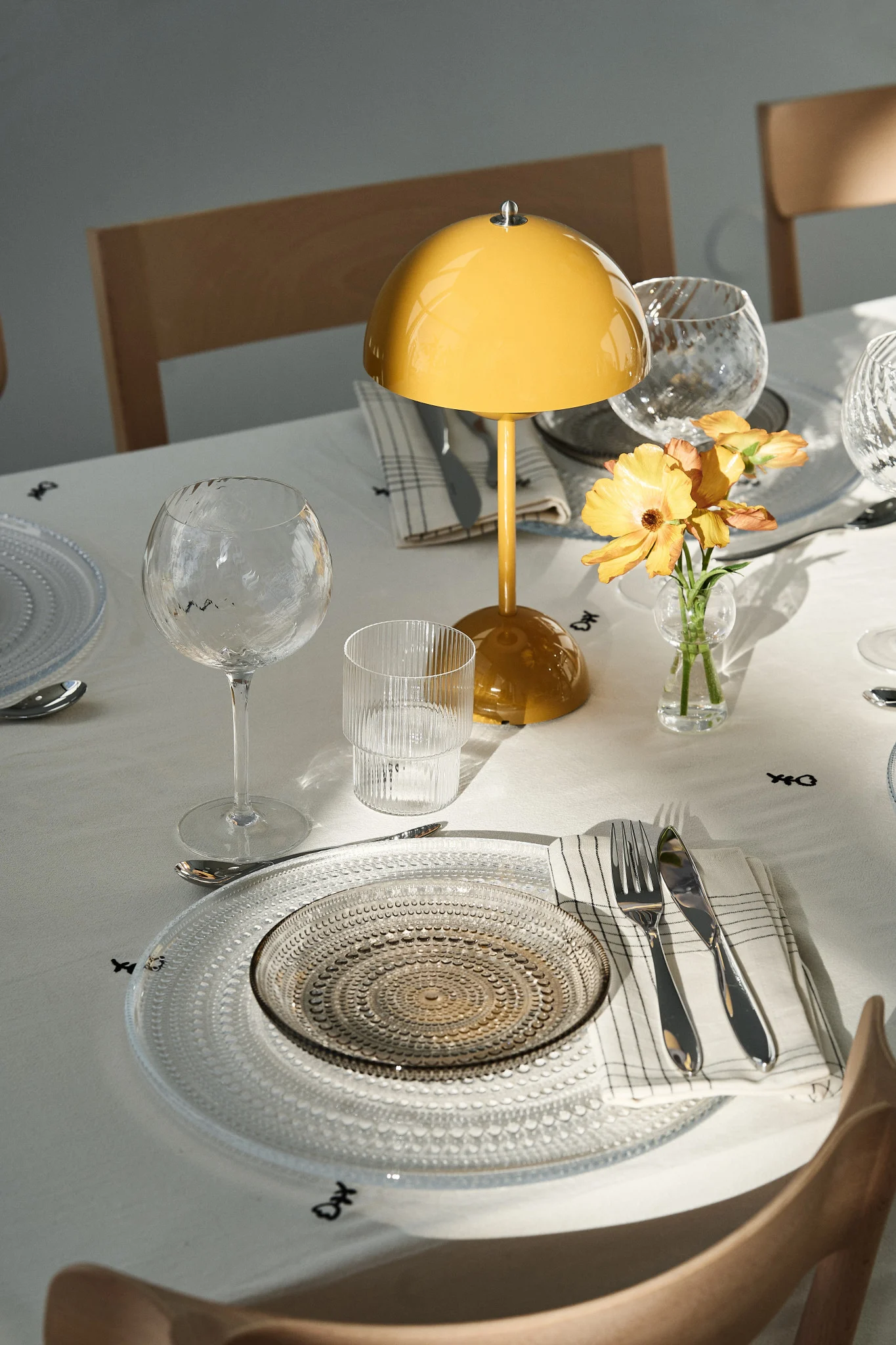 The set table is a crucial part of any party. Here you see a party setting with a portable Flowerpot lamp and festive glass plates. 
