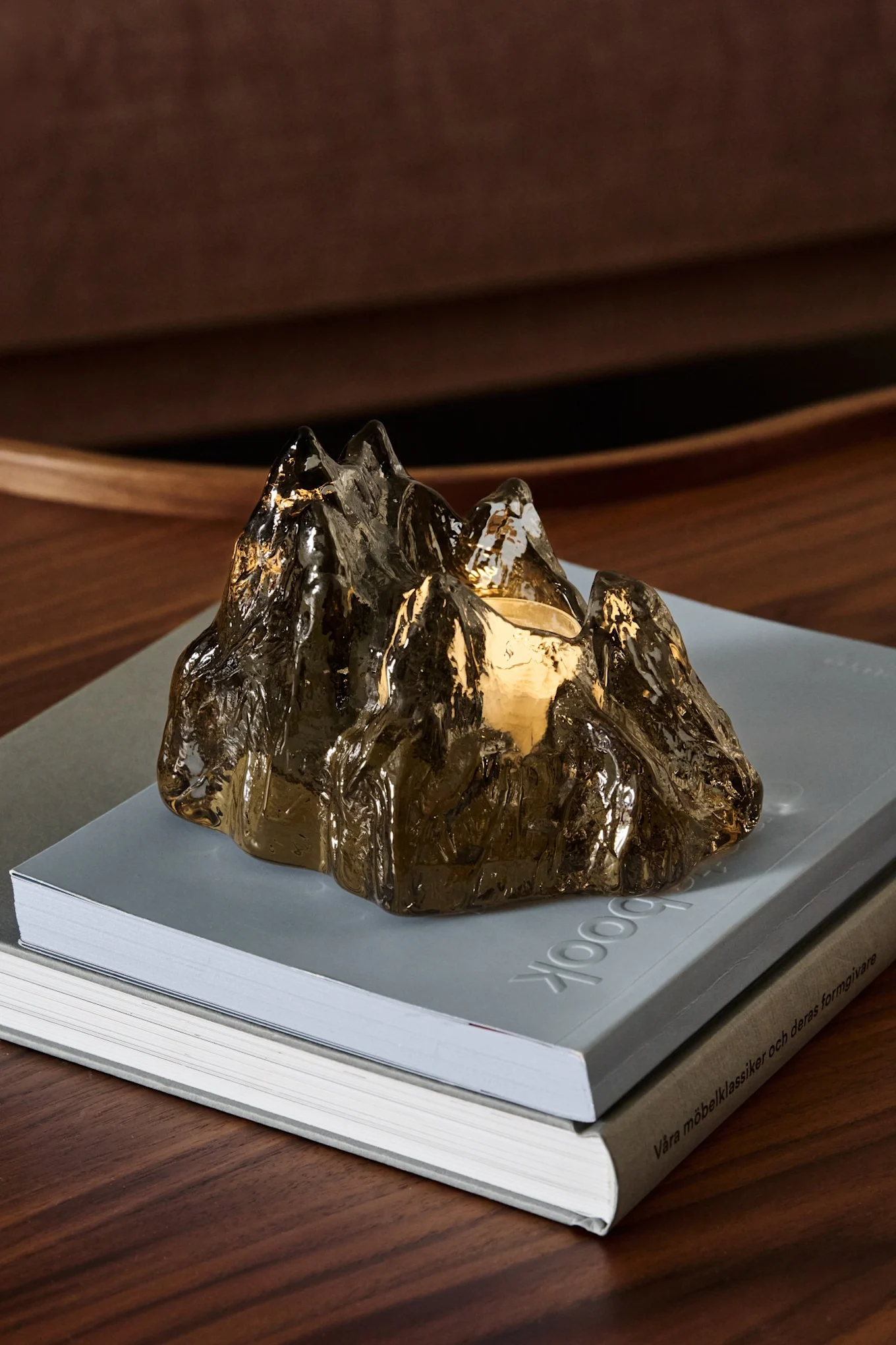 On a Nordic Nest package, the brown The Rock candle holder from Kosta Boda stands under a Christmas tree.