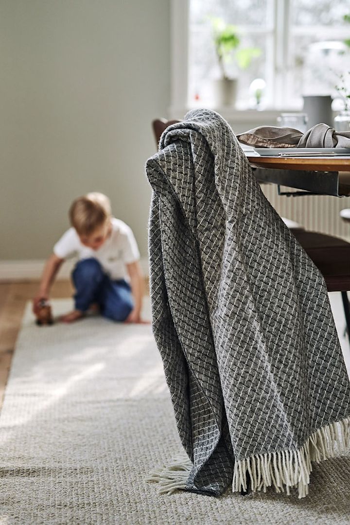 The grey wool throw from Scandi Living creates a cosy dining area, 