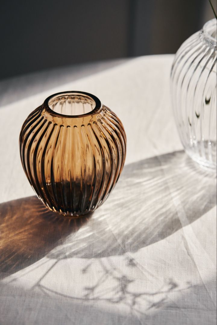 Here you see the sunlight shining through the small glass vase in walnut and the larger clear glass vase from Kähler's Hammershøi collection.
