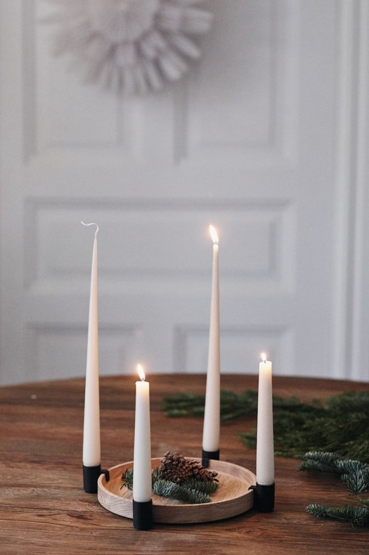 The Advent candle holder Luna in black oak from Applicata filled with pine cones is one of the year's Scandi Christmas decorations.