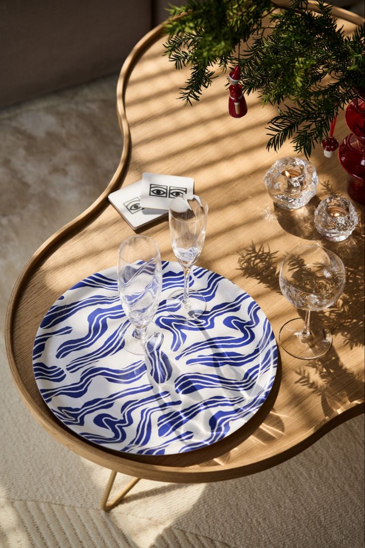 The blue sudd tray from Åry with champagne glasses on the retro Flower table from Swedese, part of the Vintage Christmas decor.
