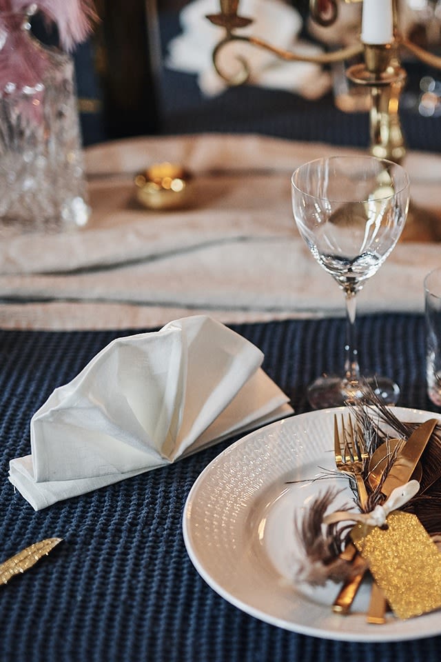 A napkin folding idea - Clean linen napkin in white from Nordic Nest folded like a classic fan, perfect for the festive New Year's table setting!