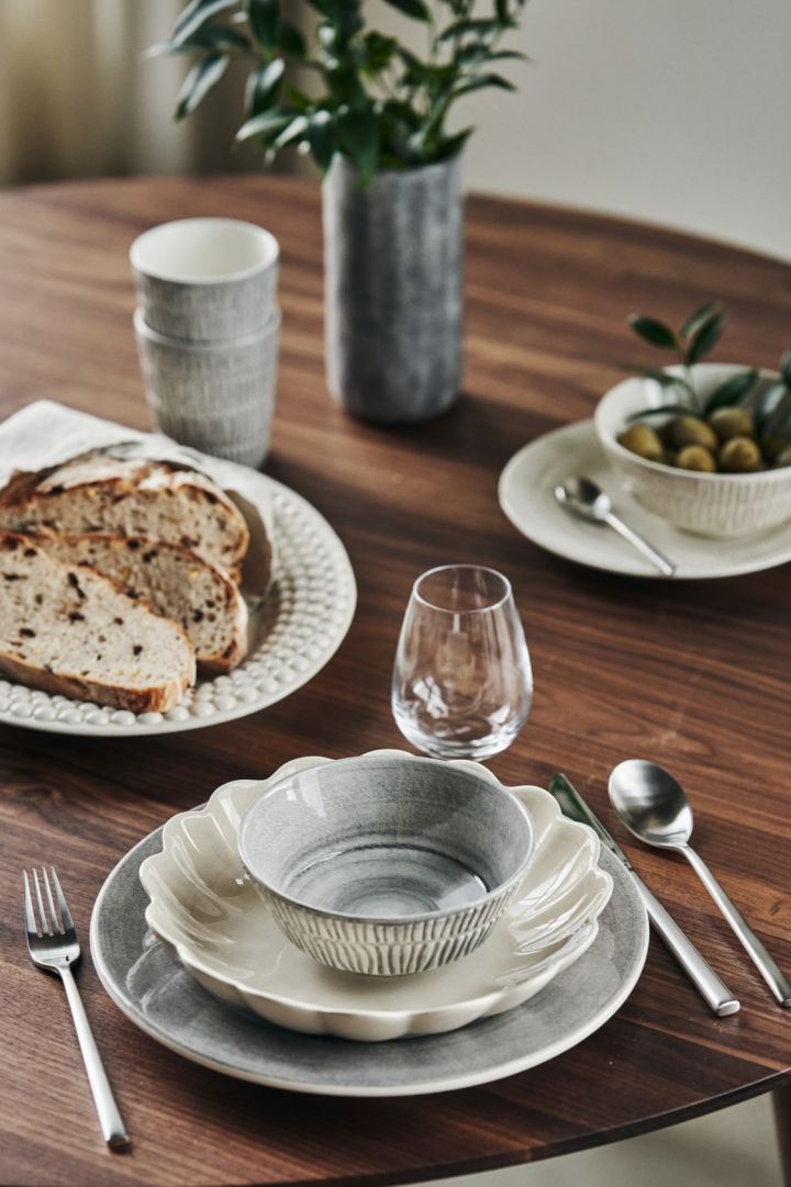 A table setting with grey and beige plates, bowls, mugs, serving plate and a jug from the Mateus Bubbles, Stripes, MSY, Basic and Oyster series'.
