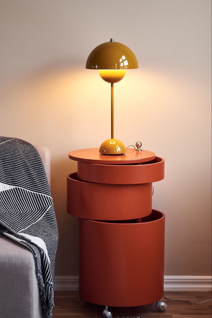 Flowerpot yellow table lamp and side table in orange from Verpan create a beautiful contrast in a neutral living room.