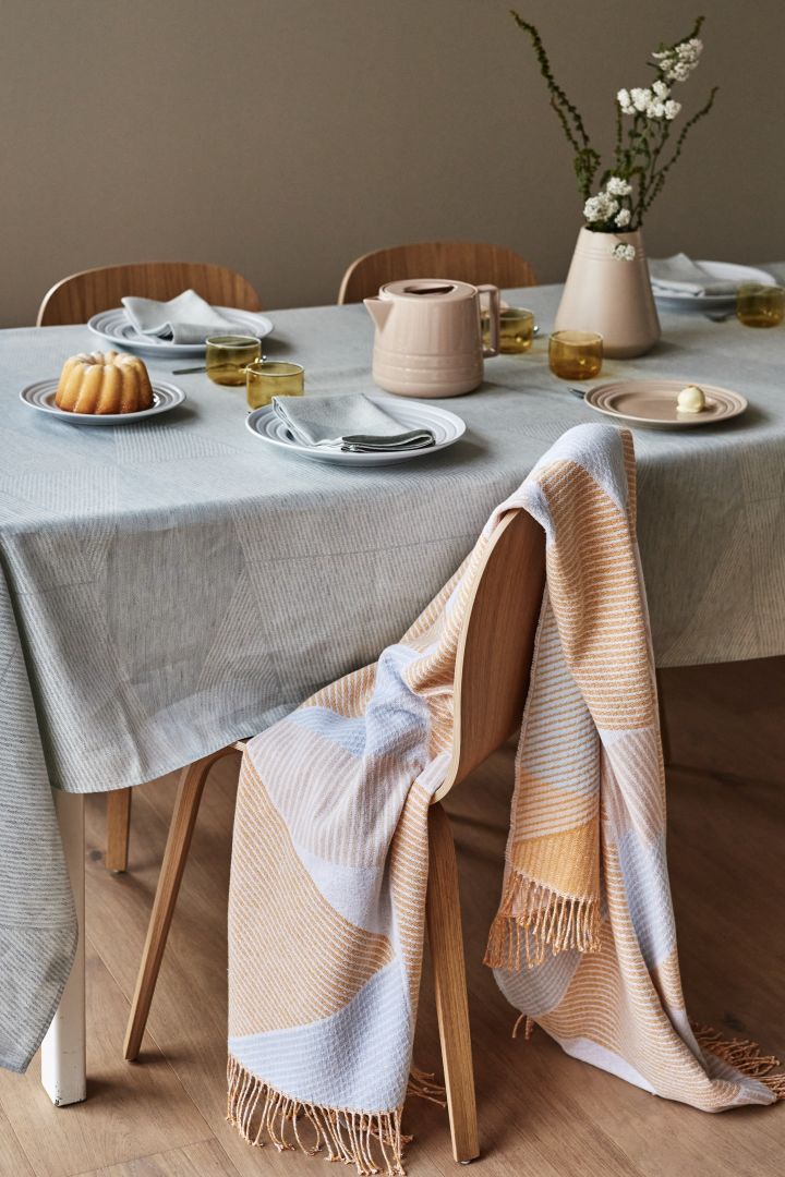 Here you see the NJRD stripes throw in a soft shade of yellow. A beautiful throw to keep your guests warm at the dining table. 