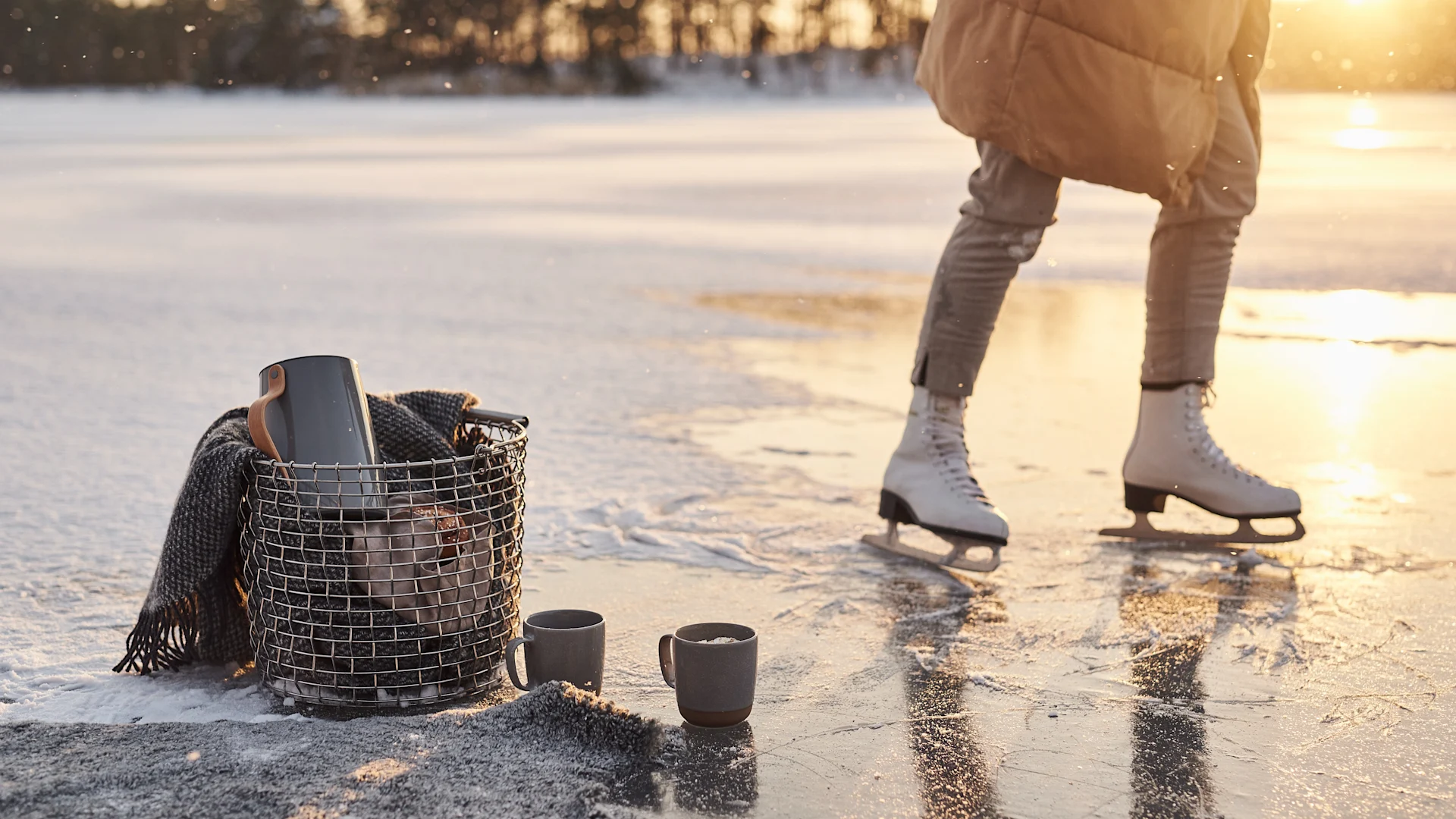 Scandinavian lifestyle things to try this winter - ice skating on a lake with a Korbo basket filled with a thermos and lots of wool blankets.