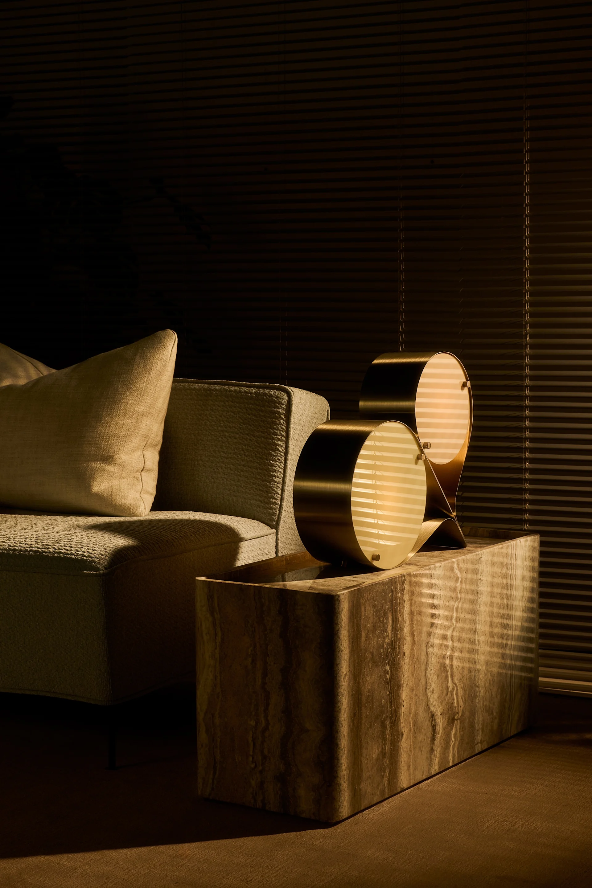 Natural colours and stone are among the interior design trends in autumn 2025. Here, the Coppia lamp stands on the Pietra side table, both from Gubi, in a living room.