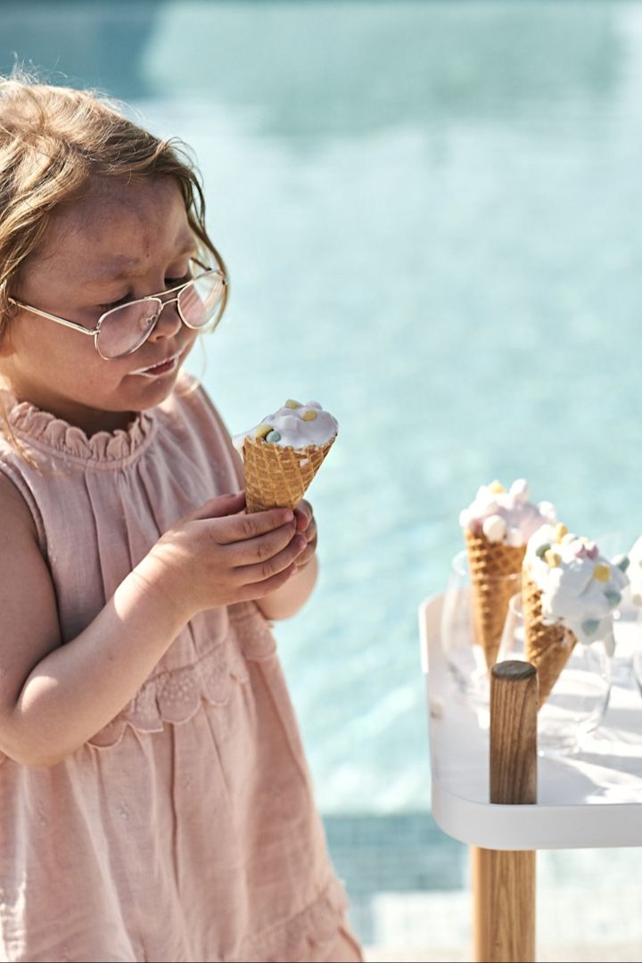 Add making your own ice cream to your summer bucket list and share it by the pool. Here you see a child eating an ice cream from a trolley next to the pool. 
