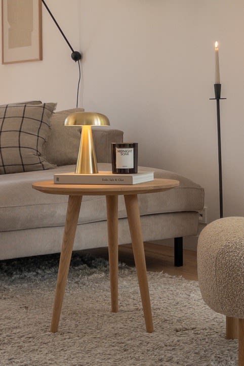 Create a Scandinavian home with @haus_tannenkamp, Here you see the Como portable table lamp on a light wood side table. 