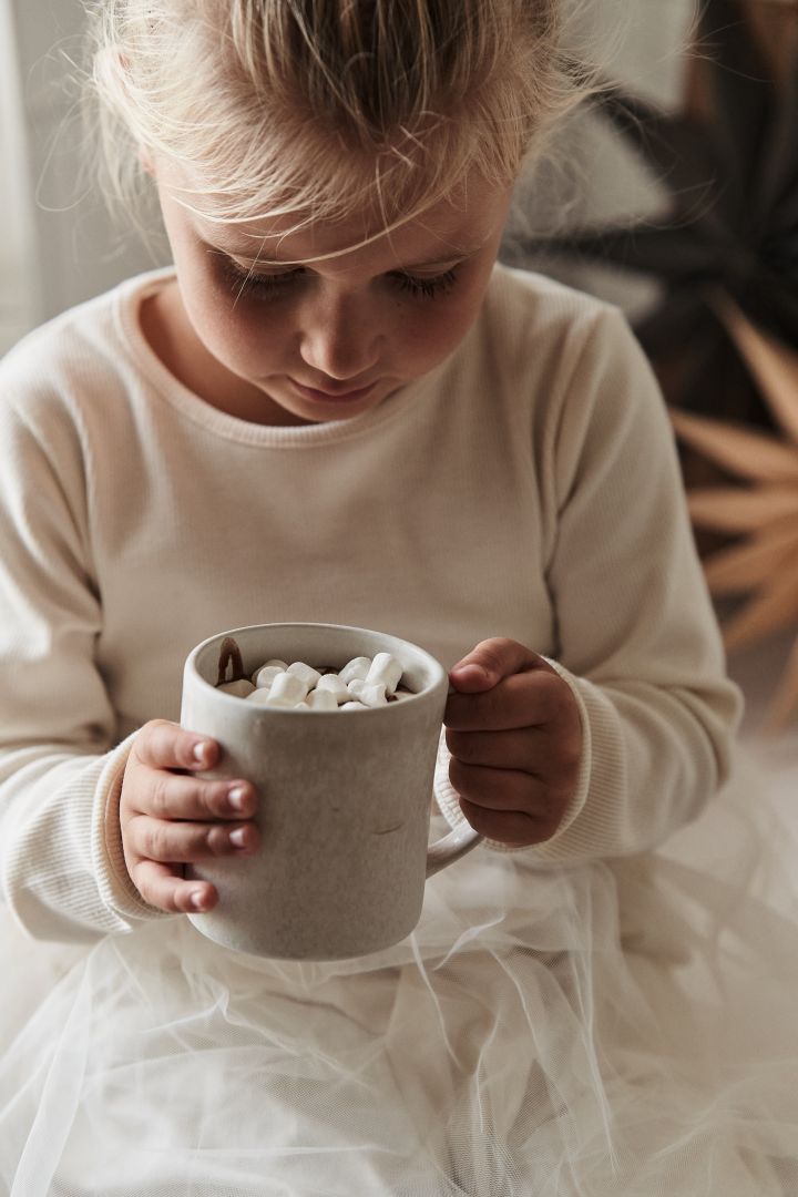 Scandinavian lifestyle things that you need to try this winter - making hot chocolate with the kids here you see a girl with the sandsbro mug from Scandi Living. 