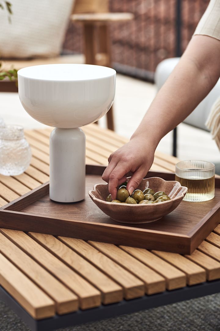 Decorate your balcony with portable lighting like the Kizu portable lamp in white marble seen here. 