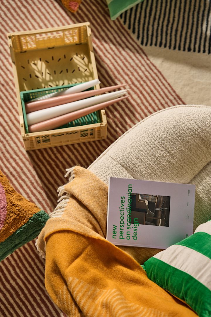 Autumn 2023 interior design trends follow in the footsteps of colour, with a colourful rug, mustard-coloured throw and green-striped cushion all making an appearance in the room this autumn. 