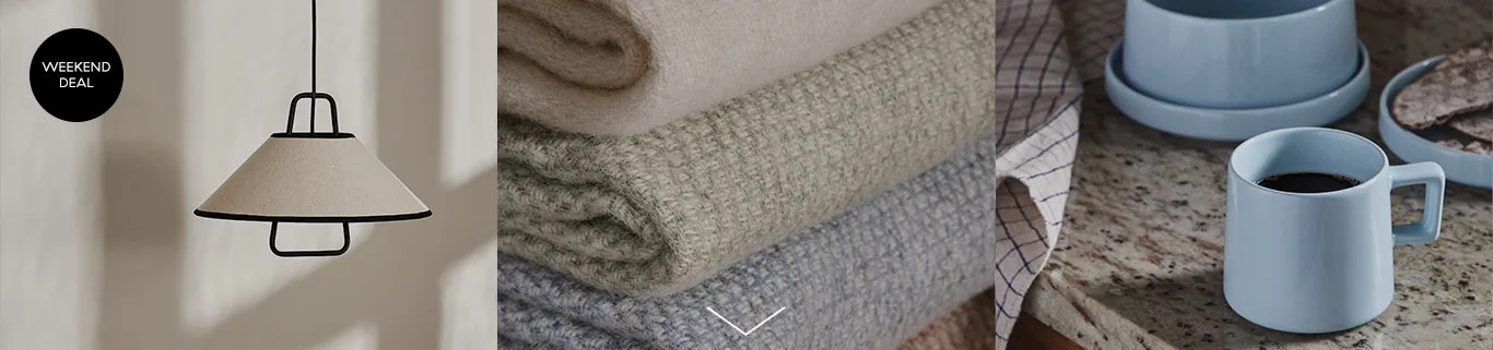 Weekend deal label, a beige pendant lamp, stacked textured blankets in neutral tones, and a light blue coffee mug with breakfast items.