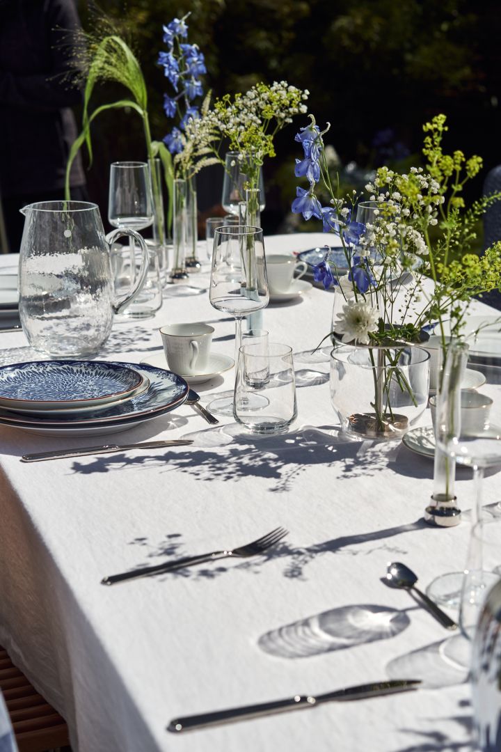 Add interest to the midsummer table with a collection of vases and blue and white flowers.
